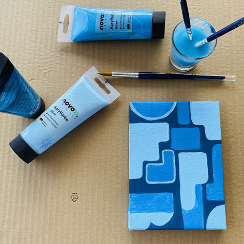 Bild mit Acrylfarben in verschiedenen Blautönen mit Pinsel und Wasser zu einem Blogbeitrag über Acrylmalen im Sommer.