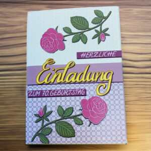 Karte zum 70. Geburtstag mit rosa Rosen und gelben handgeschriebenem Titel "Einladung" in einem Blogbeitrag über Einladungen.
