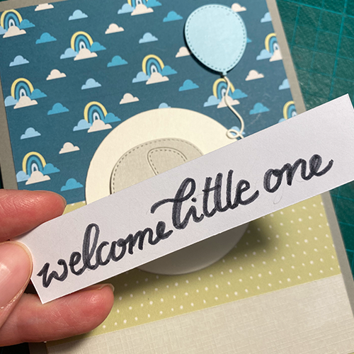 Nahaufname des hangeschriebenen Schriftzugs "welcome little one" in einem Blogbeitrag über selbstgebastelte Babykarten.
