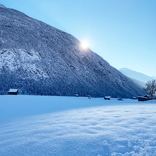 Die Sonne scheint an einem Wintermorgen ganz knapp hinter dem Berg vorbei in einem Blogbeitrag über Strategien gegen die kalte Jahreszeit.