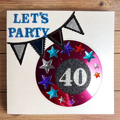 Eine selbst gebastelte Karte im scrapbooking-Stil zum 40. Geburtstag mit glitzernden Sternen und einer Girlande.