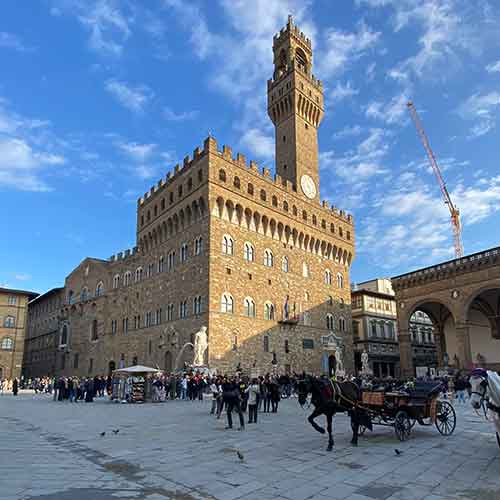 Palazzo Vecchio in Florenz mit einem blauen Himmel und ein paar weißen Wölkchen.